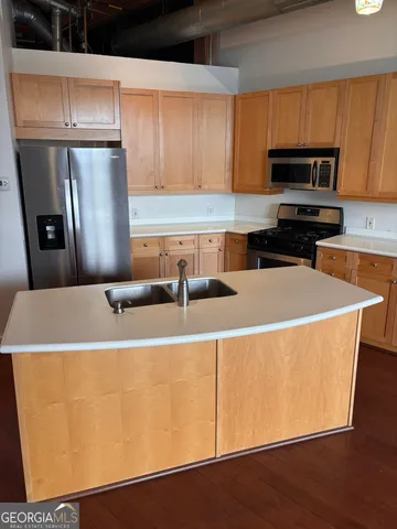 a kitchen that has a microwave a sink and a refrigerator