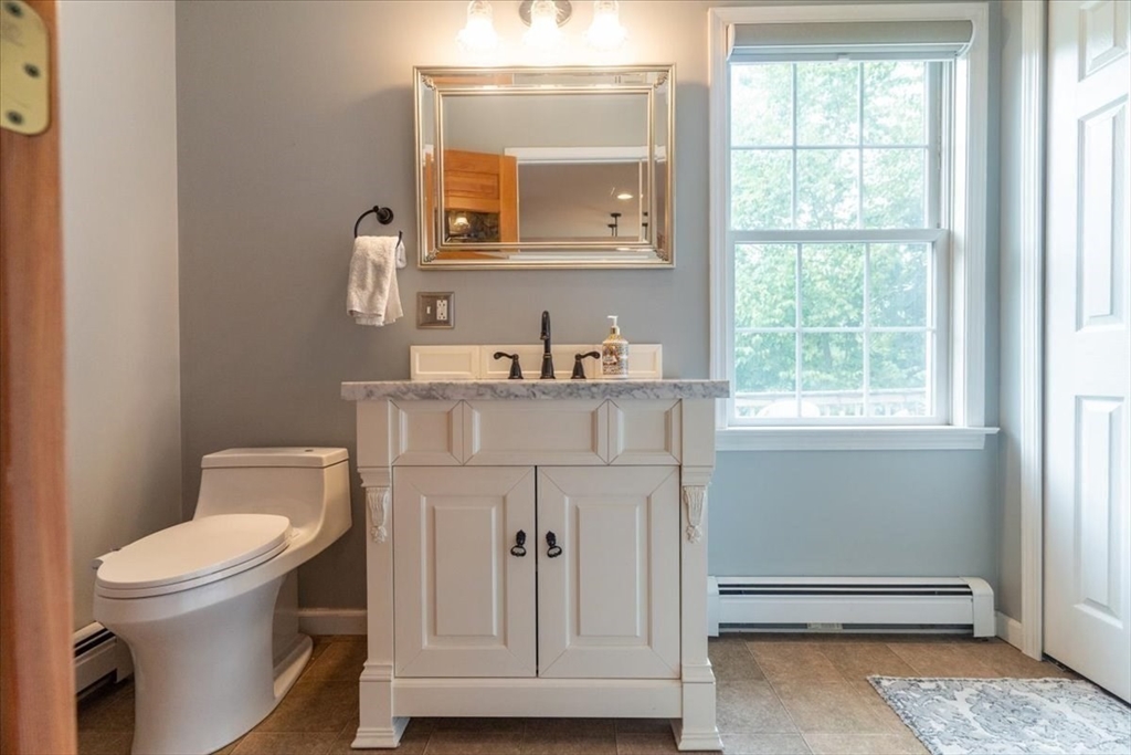 82 Hammersmith Drive Saugus, MA 01906 - Photo 16 of 42 a bathroom with a toilet a sink a vanity a window and mirror