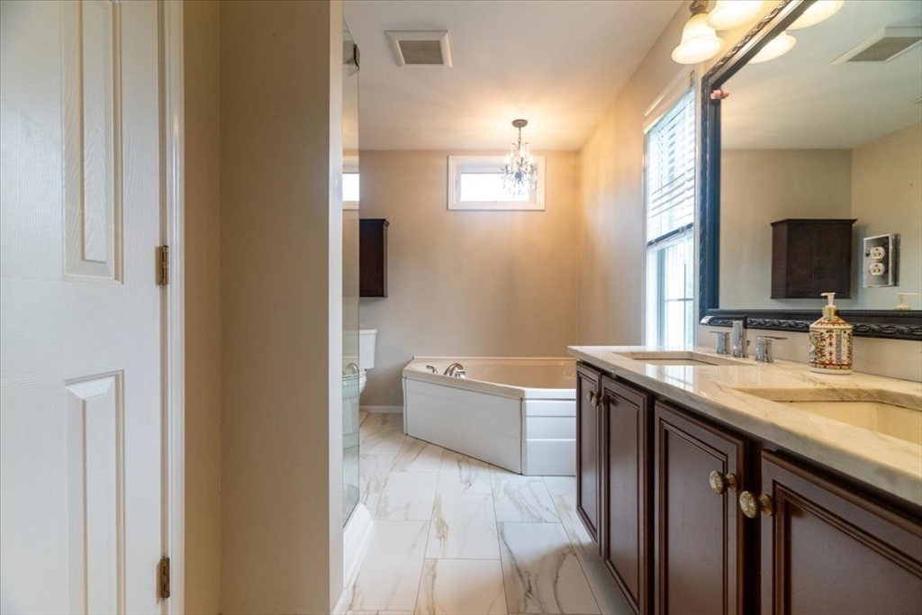 82 Hammersmith Drive Saugus, MA 01906 - Photo 23 of 42 a spacious bathroom with a granite countertop sink a toilet and mirror