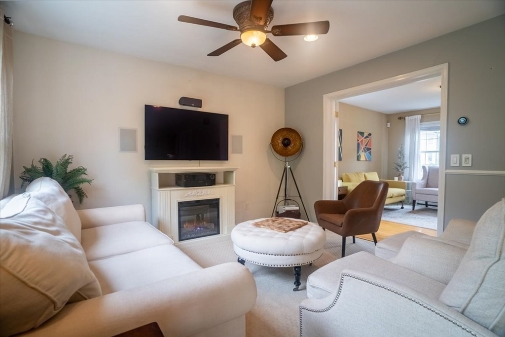82 Hammersmith Drive Saugus, MA 01906 - Photo 5 of 42 a living room with furniture a fireplace and a flat screen tv