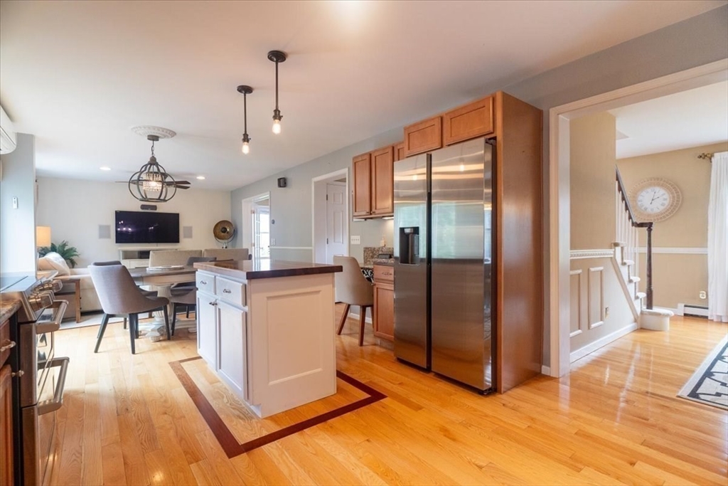 82 Hammersmith Drive Saugus, MA 01906 - Photo 9 of 42 a living room with stainless steel appliances kitchen island granite countertop a refrigerator a stove top oven and a dining table with wooden floor