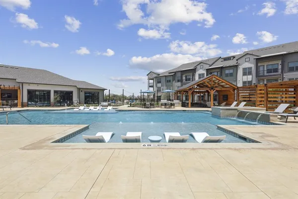 a view of house with swimming pool and yard