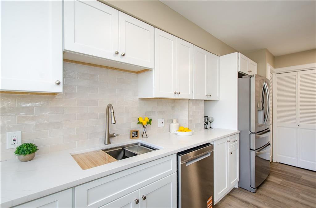 3530 Piedmont Road Northeast, Unit F5 Atlanta, GA 30305 - Photo 12 of 28 a kitchen with stainless steel appliances white cabinets a refrigerator a sink a stove and wooden floor