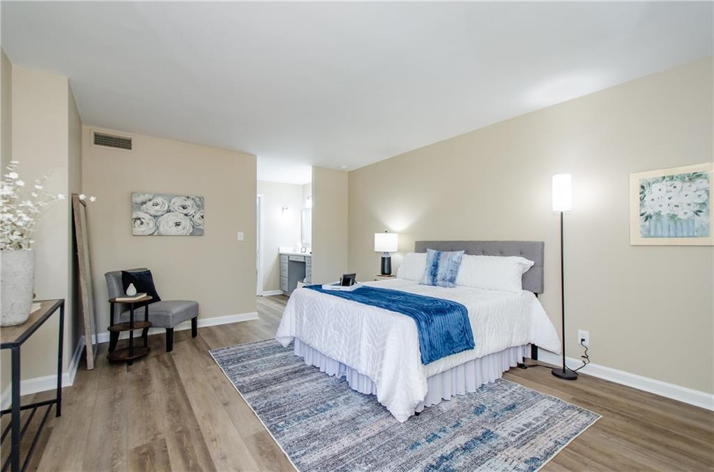 3530 Piedmont Road Northeast, Unit F5 Atlanta, GA 30305 - Photo 17 of 28 a spacious bedroom with a bed a table and chair
