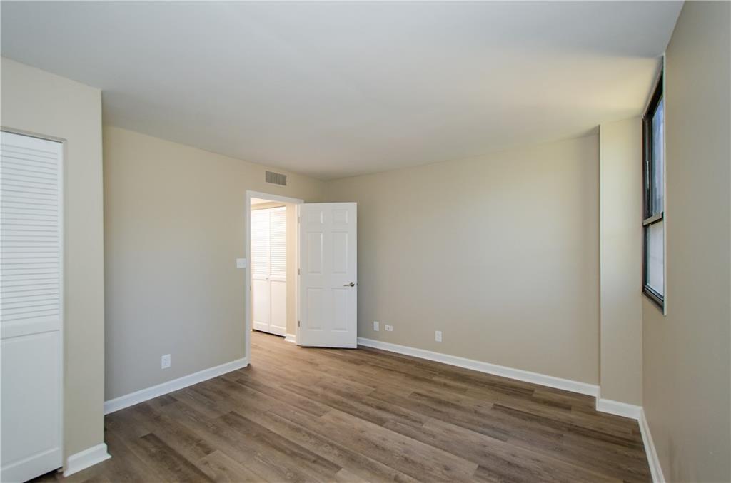 3530 Piedmont Road Northeast, Unit F5 Atlanta, GA 30305 - Photo 23 of 28 a view of an empty room with wooden floor and a window