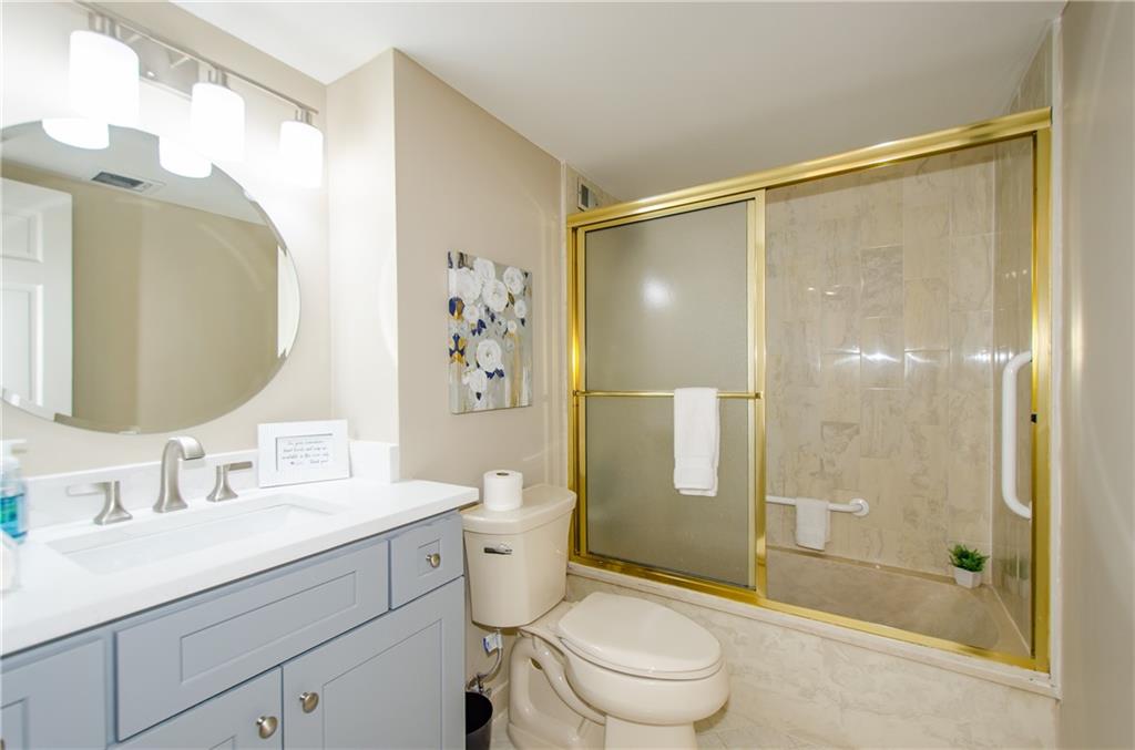 3530 Piedmont Road Northeast, Unit F5 Atlanta, GA 30305 - Photo 24 of 28 a bathroom with a shower sink vanity mirror and toilet