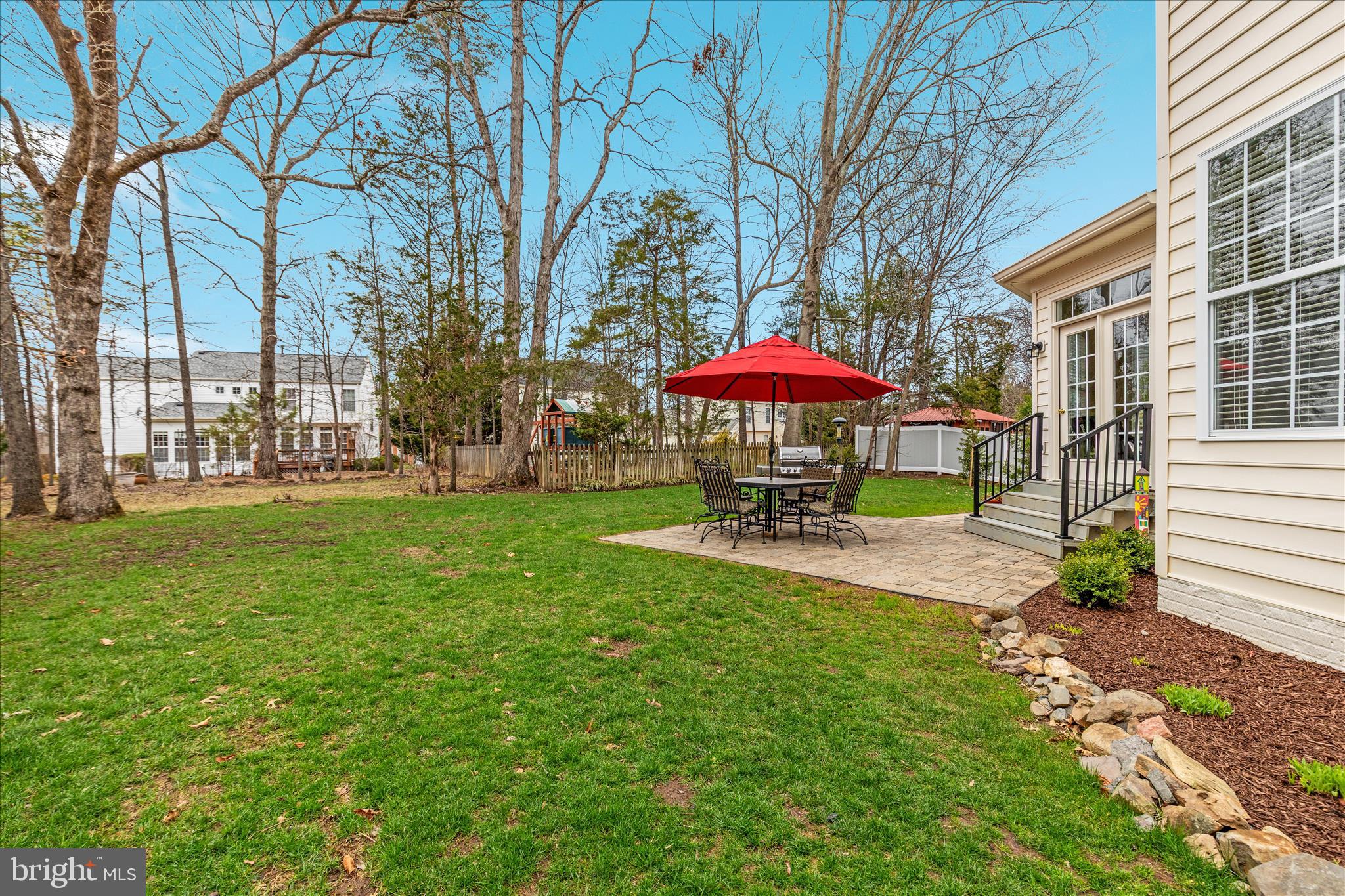 10116 Middlebrooks Terrace Nokesville, VA 20181 - Photo 51 of 78 a view of a swimming pool with a table and chairs under an umbrella