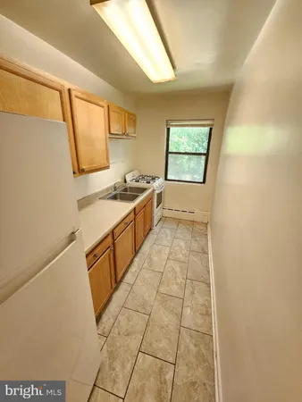 a kitchen with a sink a stove top oven and cabinetry