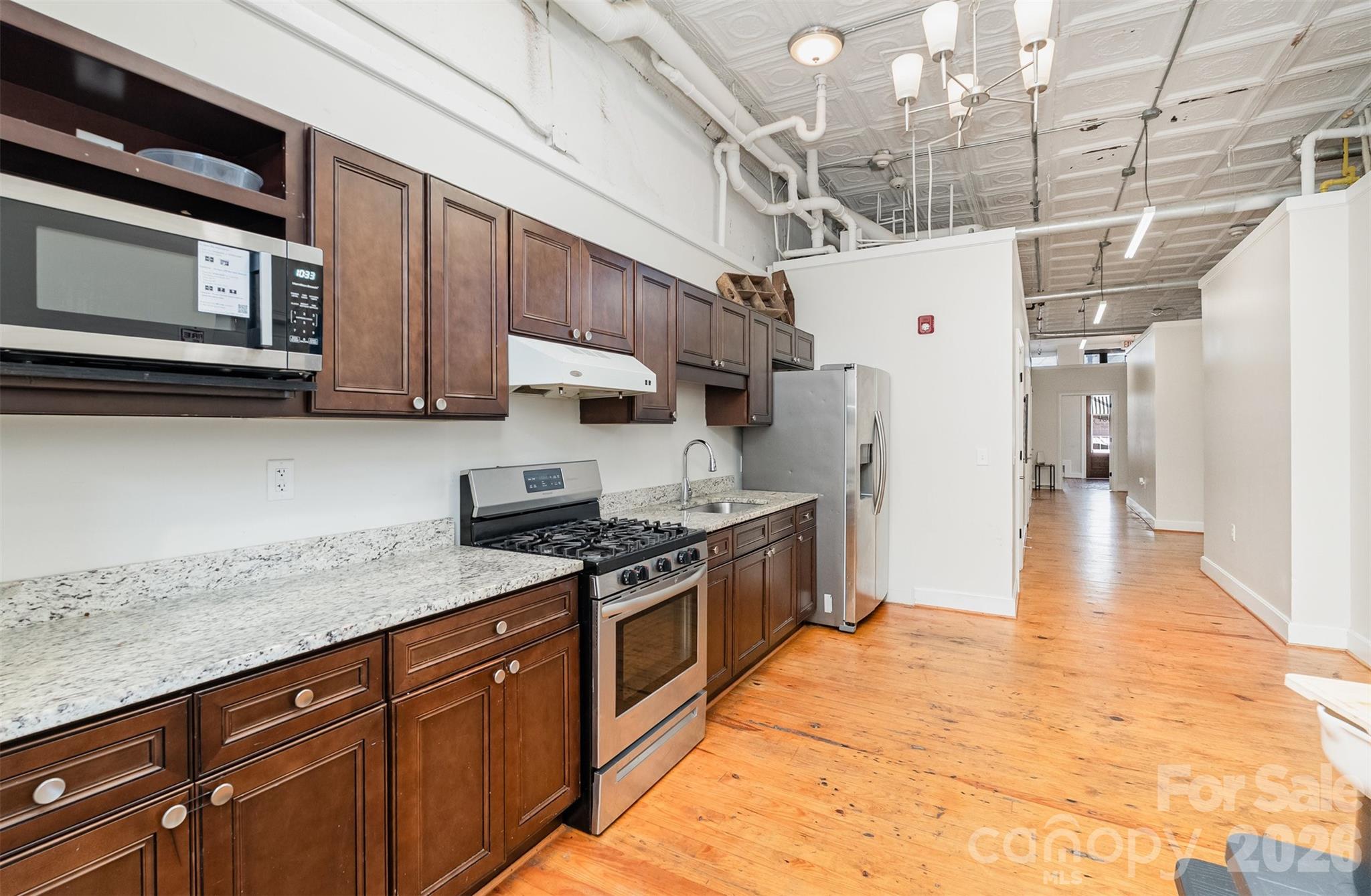 101 West Main Street Union, SC 29379 - Photo 8 of 29 a kitchen with stainless steel appliances granite countertop a refrigerator a stove and wooden cabinets