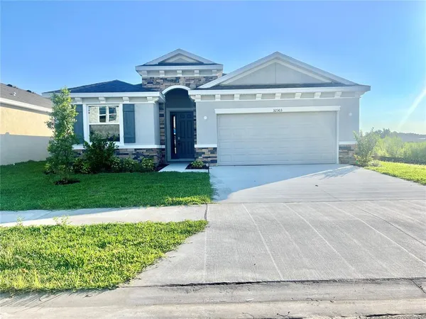 a front view of a house with a yard and garage
