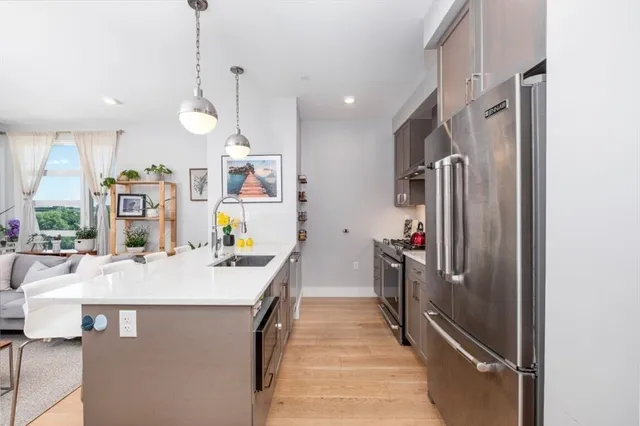 a kitchen with stainless steel appliances kitchen island granite countertop a refrigerator and a stove