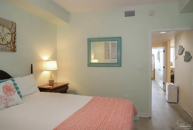 a bedroom with a bed chandelier and a window