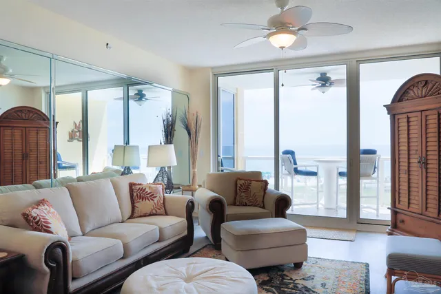 a living room with furniture a flat screen tv and a large window