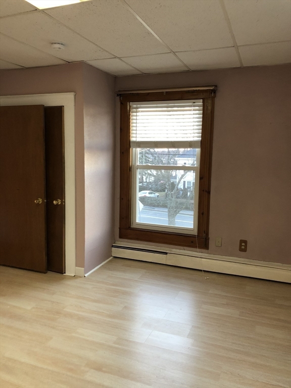 184 Middle Street, Unit 2 Braintree, MA 02184 - Photo 11 of 14 an empty room with wooden floor and windows