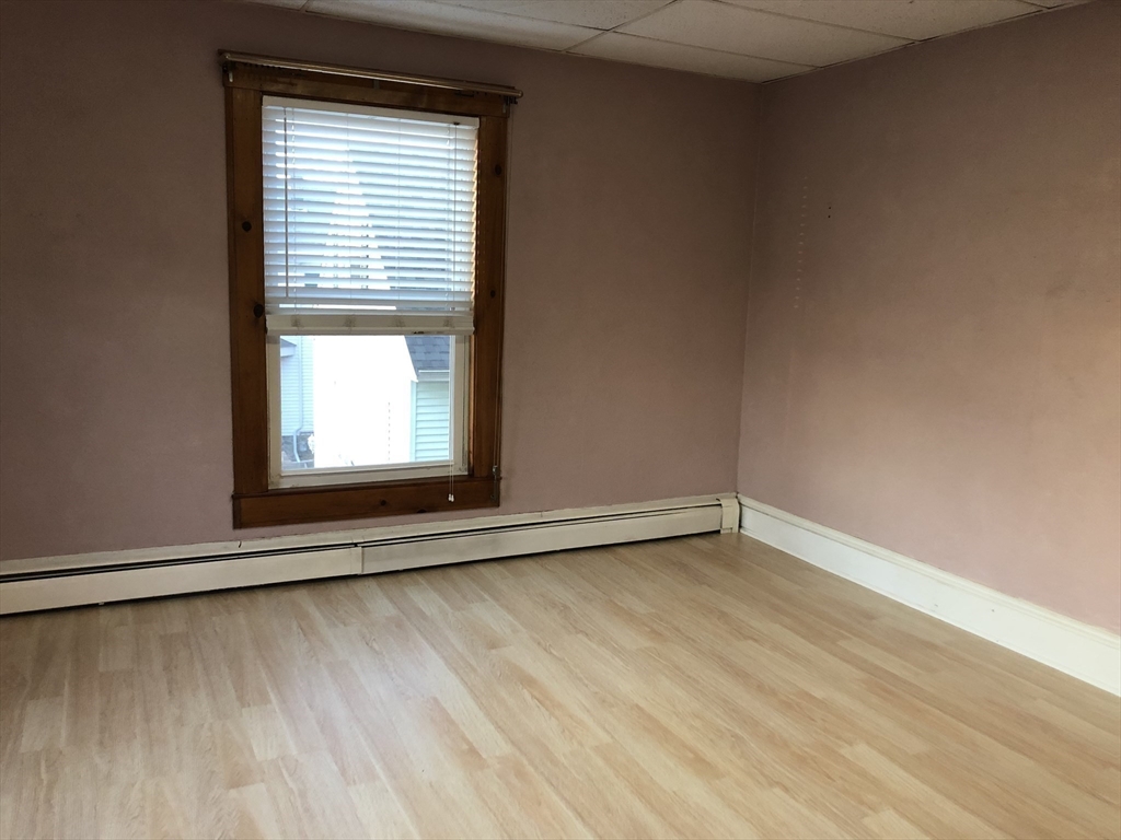184 Middle Street, Unit 2 Braintree, MA 02184 - Photo 13 of 14 an empty room with wooden floor and windows