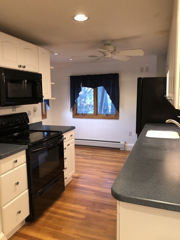184 Middle Street, Unit 2 Braintree, MA 02184 - Photo 2 of 14 a kitchen with stainless steel appliances kitchen island granite countertop a stove a sink and a microwave