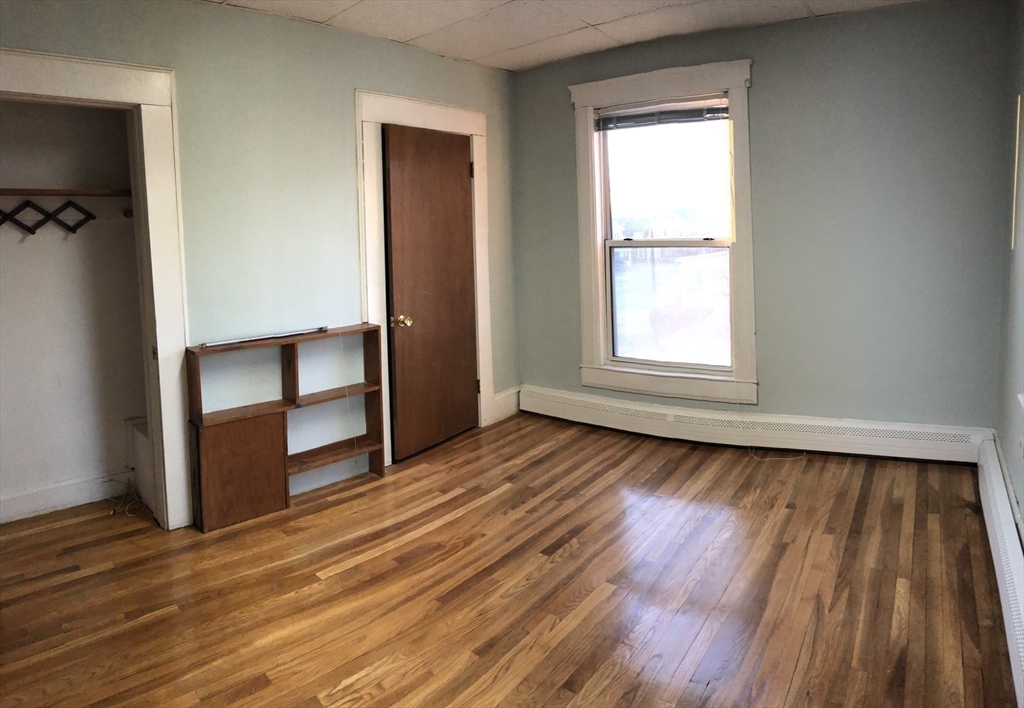 184 Middle Street, Unit 2 Braintree, MA 02184 - Photo 10 of 14 an empty room with wooden floor closet and windows