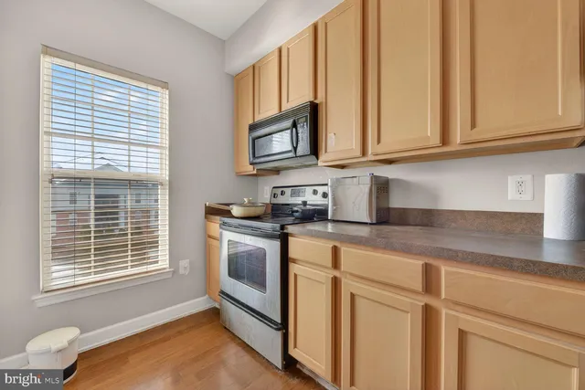 a kitchen with granite countertop cabinets appliances and a sink