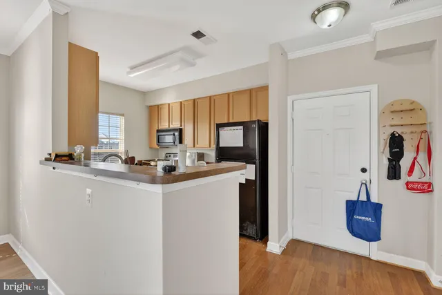 a kitchen with sink a refrigerator and wooden floor