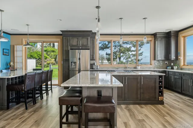 a kitchen with a wooden table chairs and large window