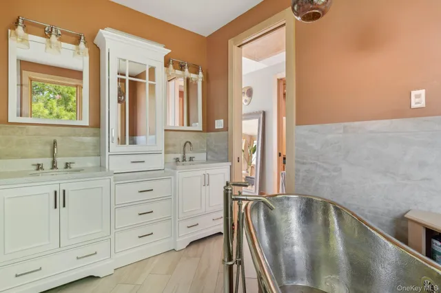 a bathroom with a sink a bathtub and a mirror