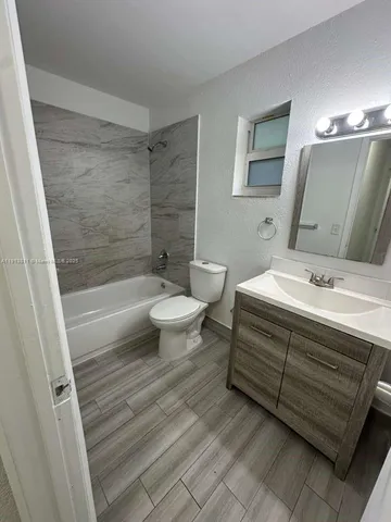 a bathroom with a sink a toilet a mirror and bathtub