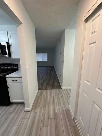 a view of a kitchen from a hallway