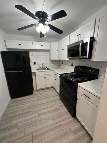 a kitchen with a stove sink and cabinets