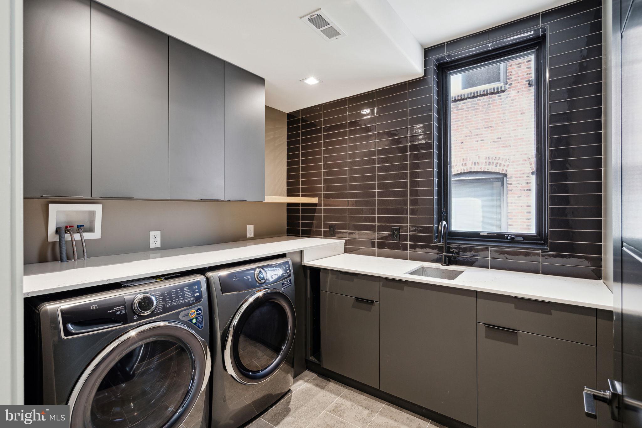 110 South Bonsall Street Philadelphia, PA 19103 - Photo 14 of 25 a utility room with stainless steel appliances a sink a washer and dryer next to a window