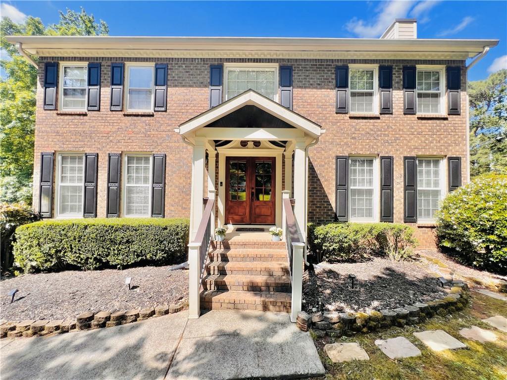 front view of a brick house with a yard
