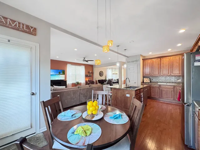 a view of a dining room with furniture a kitchen and wooden floor