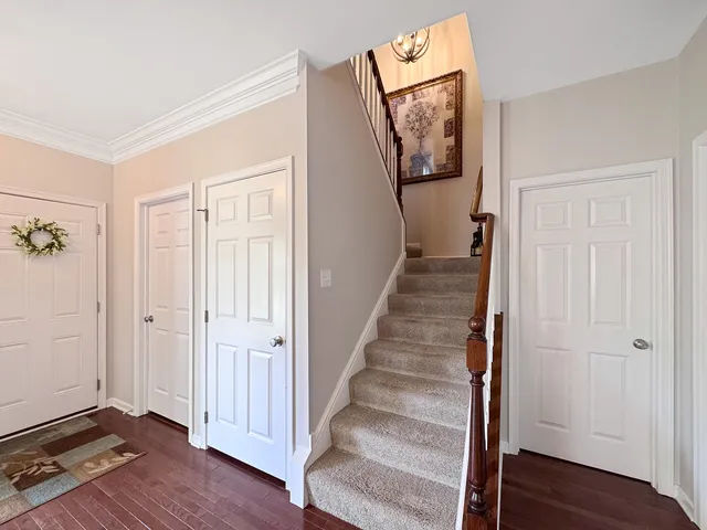 a view of a hallway with wooden floor and staircase