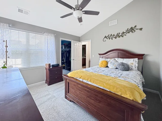 a spacious bedroom with a bed and wooden floor