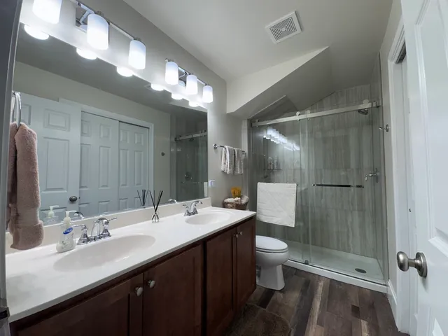 a bathroom with a double vanity sink mirror and toilet