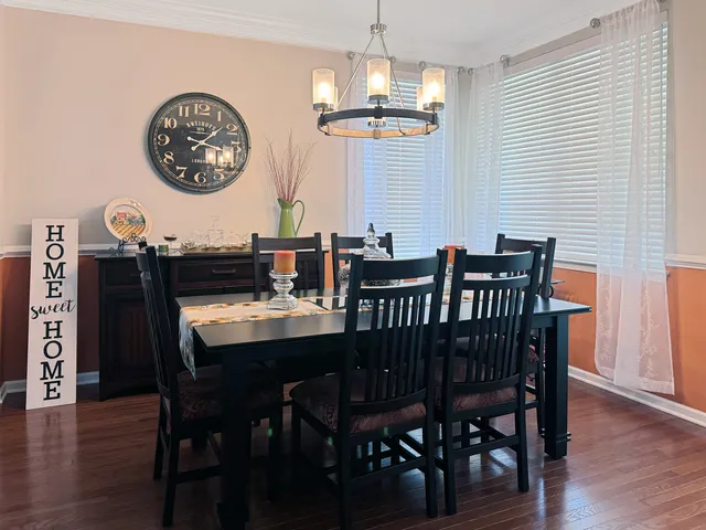 a view of a dining room with furniture wooden floor and chandelier