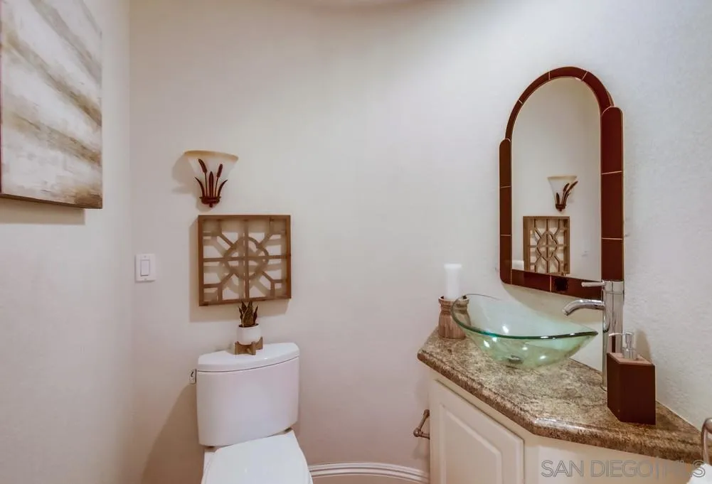 16052 Country Day Road Poway, CA 92064 - Photo 44 of 75 a bathroom with a granite countertop sink a toilet and a mirror