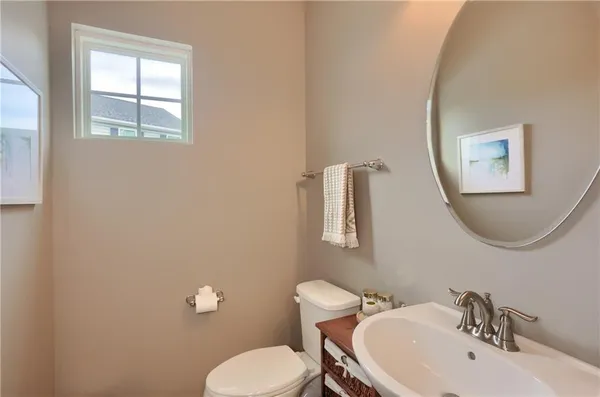 a bathroom with a toilet a sink and mirror