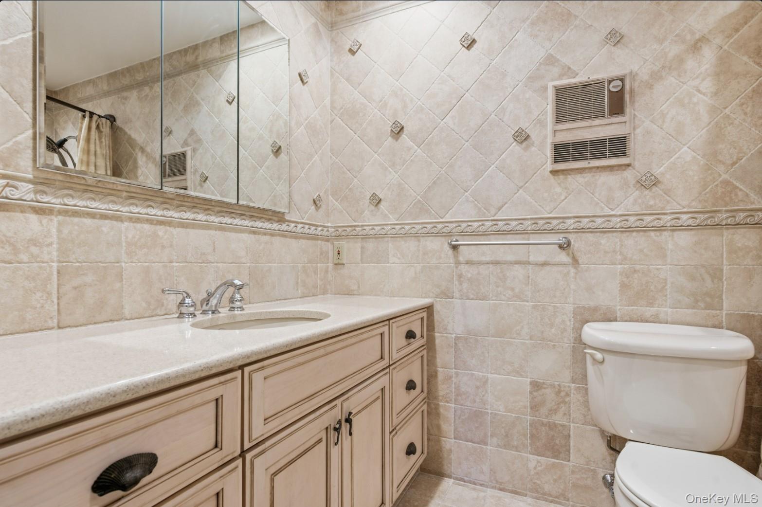 253 Dune Road, Unit 49 Westhampton Beach, NY 11978 - Photo 13 of 31 a bathroom with a sink a toilet and shower