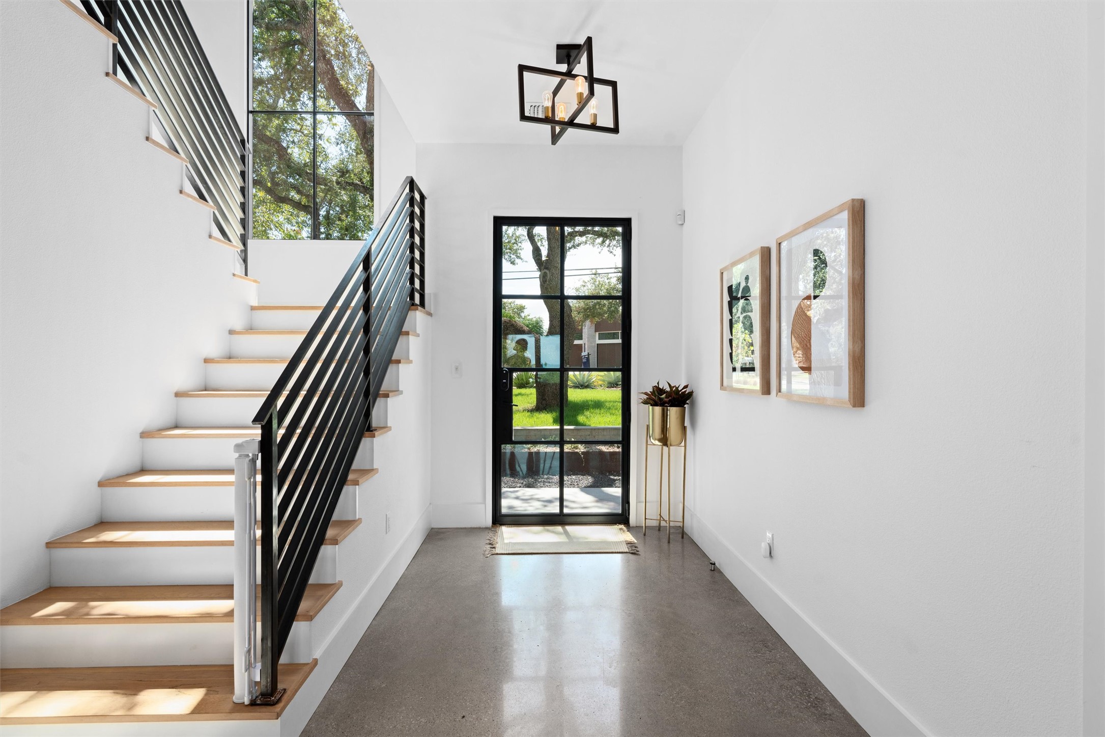 1500 The High Road Austin, TX 78746 - Photo 2 of 40 Two-story entryway with a black-framed glass door, polished concrete flooring, white walls, and a contemporary ceiling light fixture