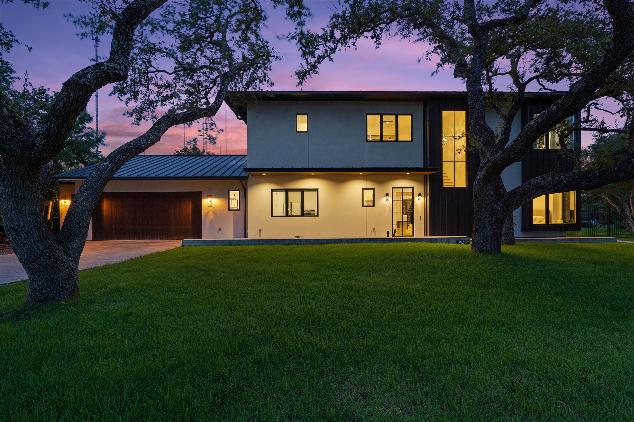 1500 The High Road Austin, TX 78746 - Photo 40 of 40 Modern architecture featuring a smooth stucco exterior, dark vertical siding, and abundant windows