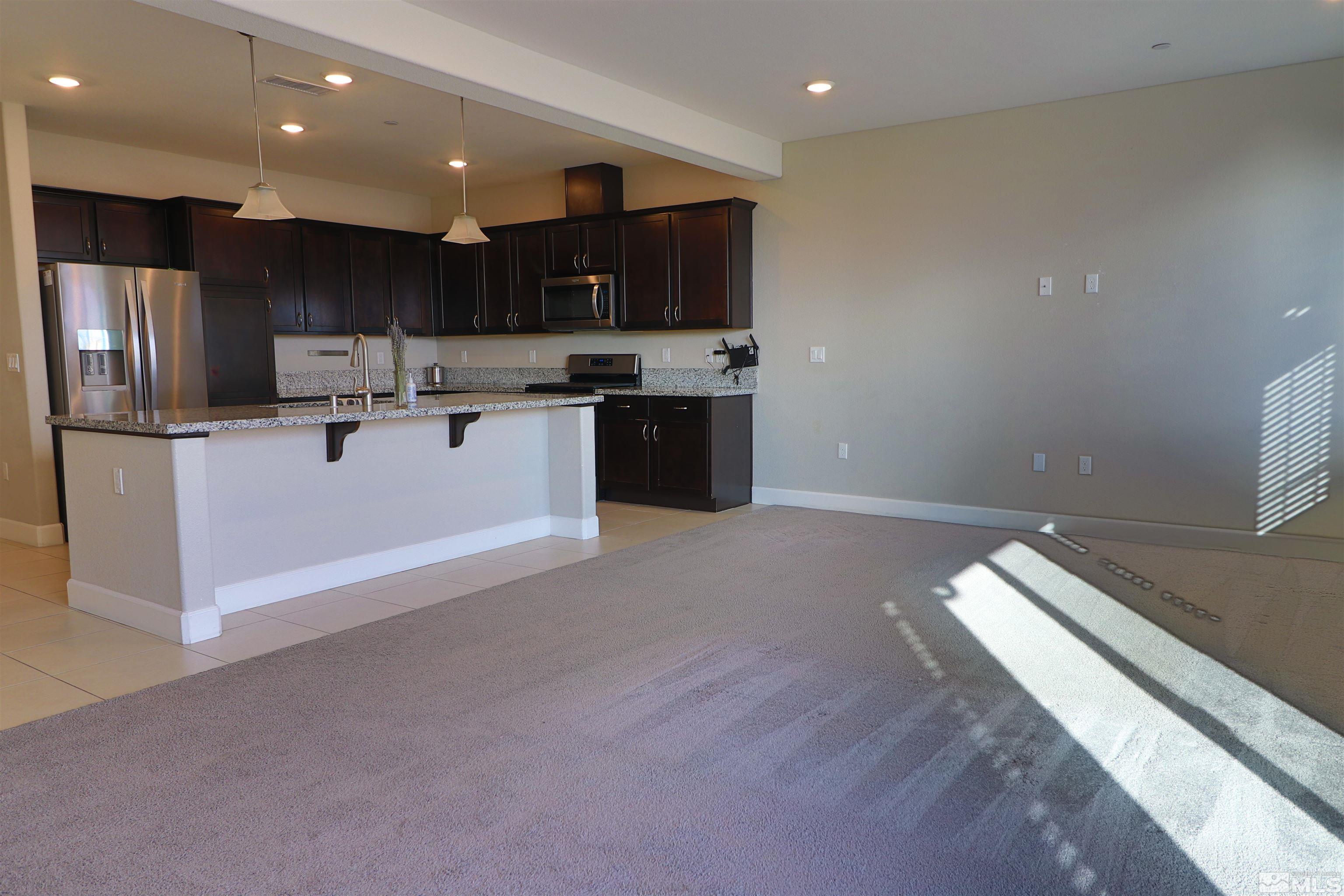 1920 Dark Horse Road, Unit C Reno, NV 89521 - Photo 3 of 26 a kitchen with stainless steel appliances kitchen island granite countertop a stove a sink and a refrigerator