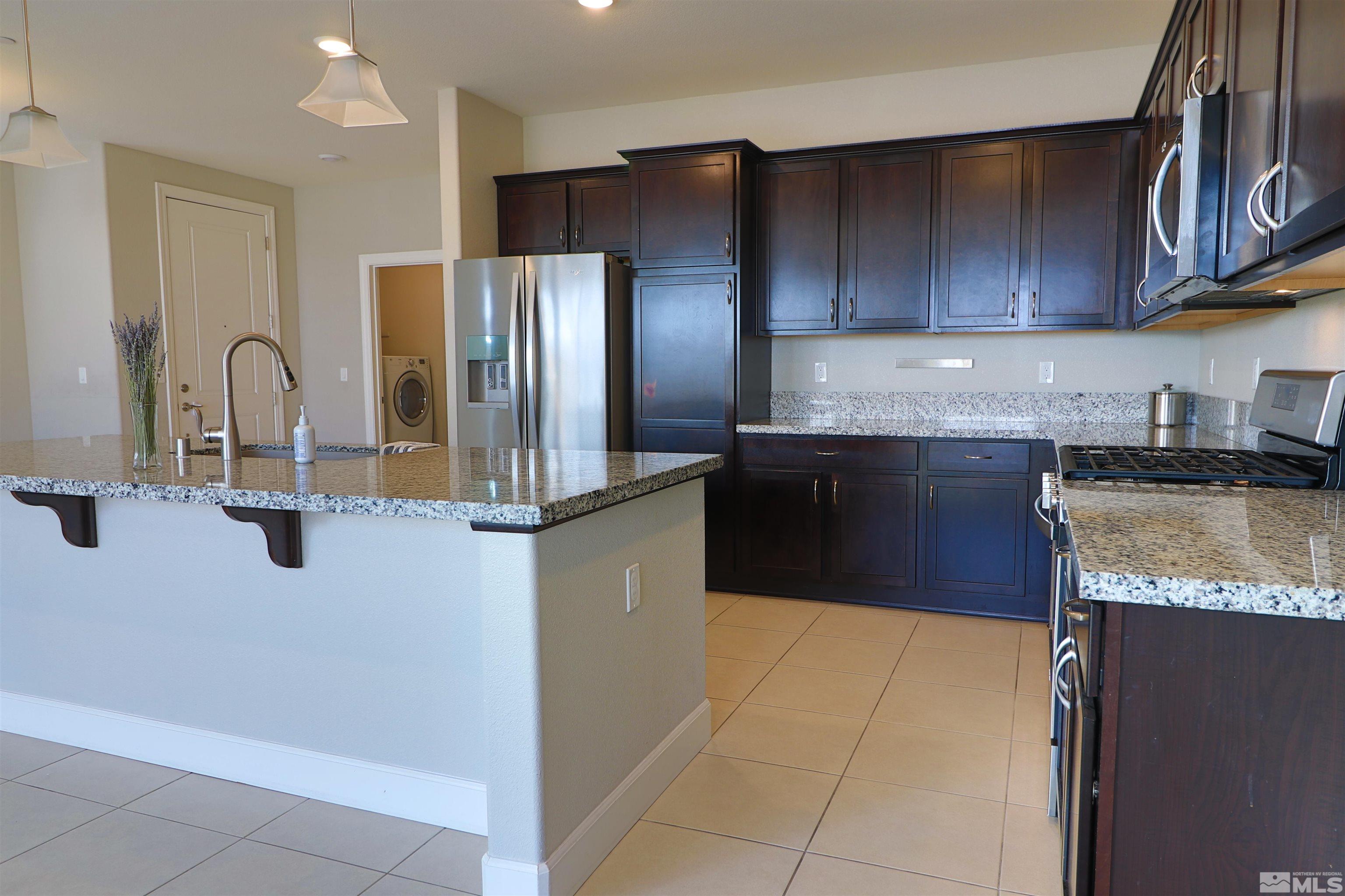 1920 Dark Horse Road, Unit C Reno, NV 89521 - Photo 5 of 26 a kitchen with stainless steel appliances granite countertop a refrigerator and a stove