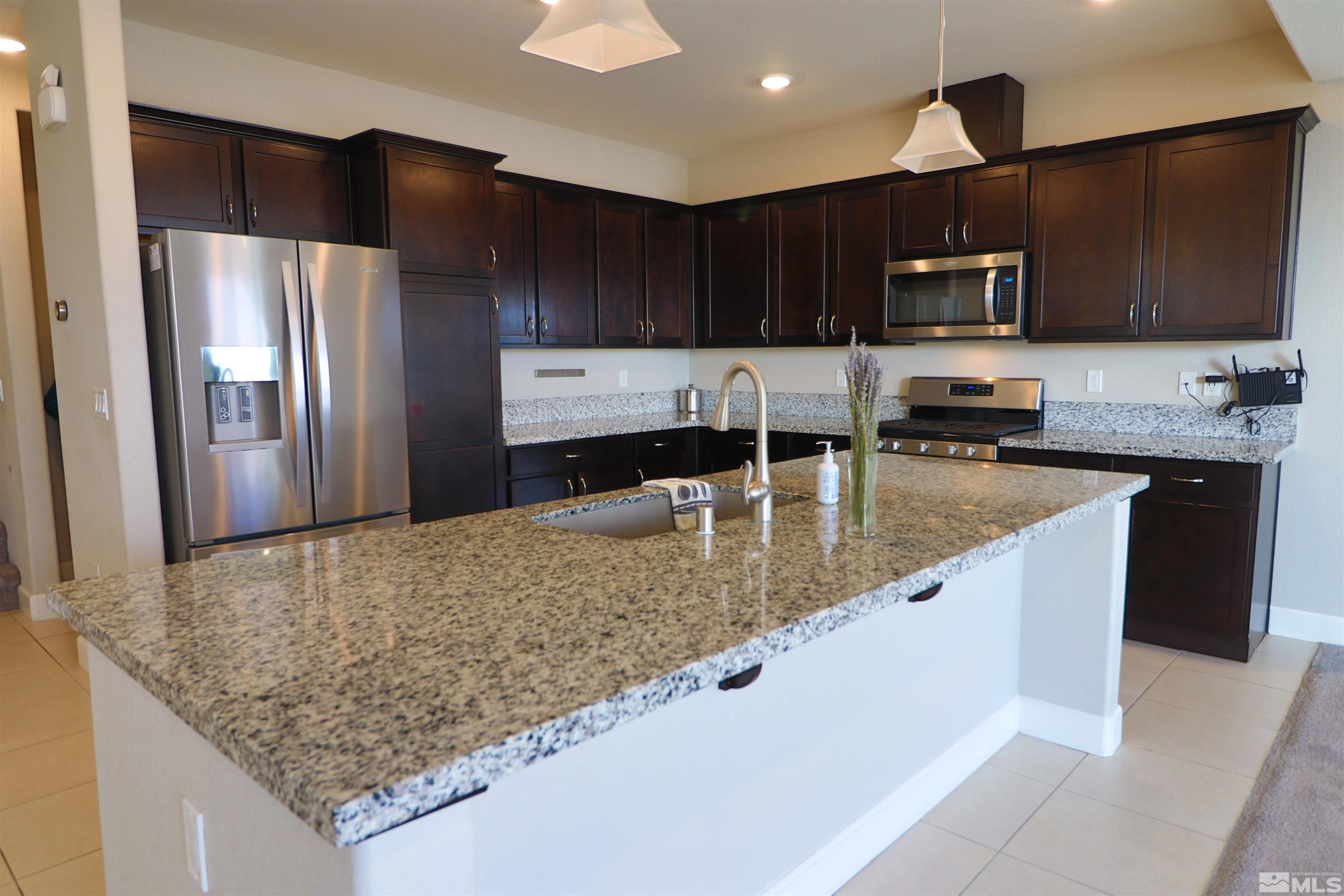 1920 Dark Horse Road, Unit C Reno, NV 89521 - Photo 6 of 26 a kitchen with stainless steel appliances granite countertop a sink refrigerator and microwave
