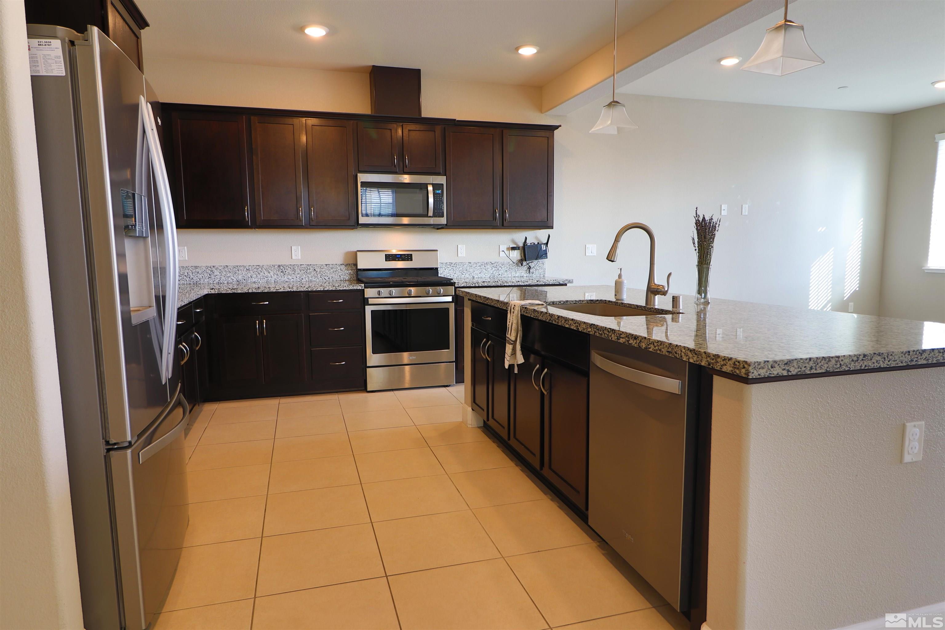 1920 Dark Horse Road, Unit C Reno, NV 89521 - Photo 7 of 26 a kitchen with stainless steel appliances granite countertop a refrigerator a sink a stove top oven and a refrigerator