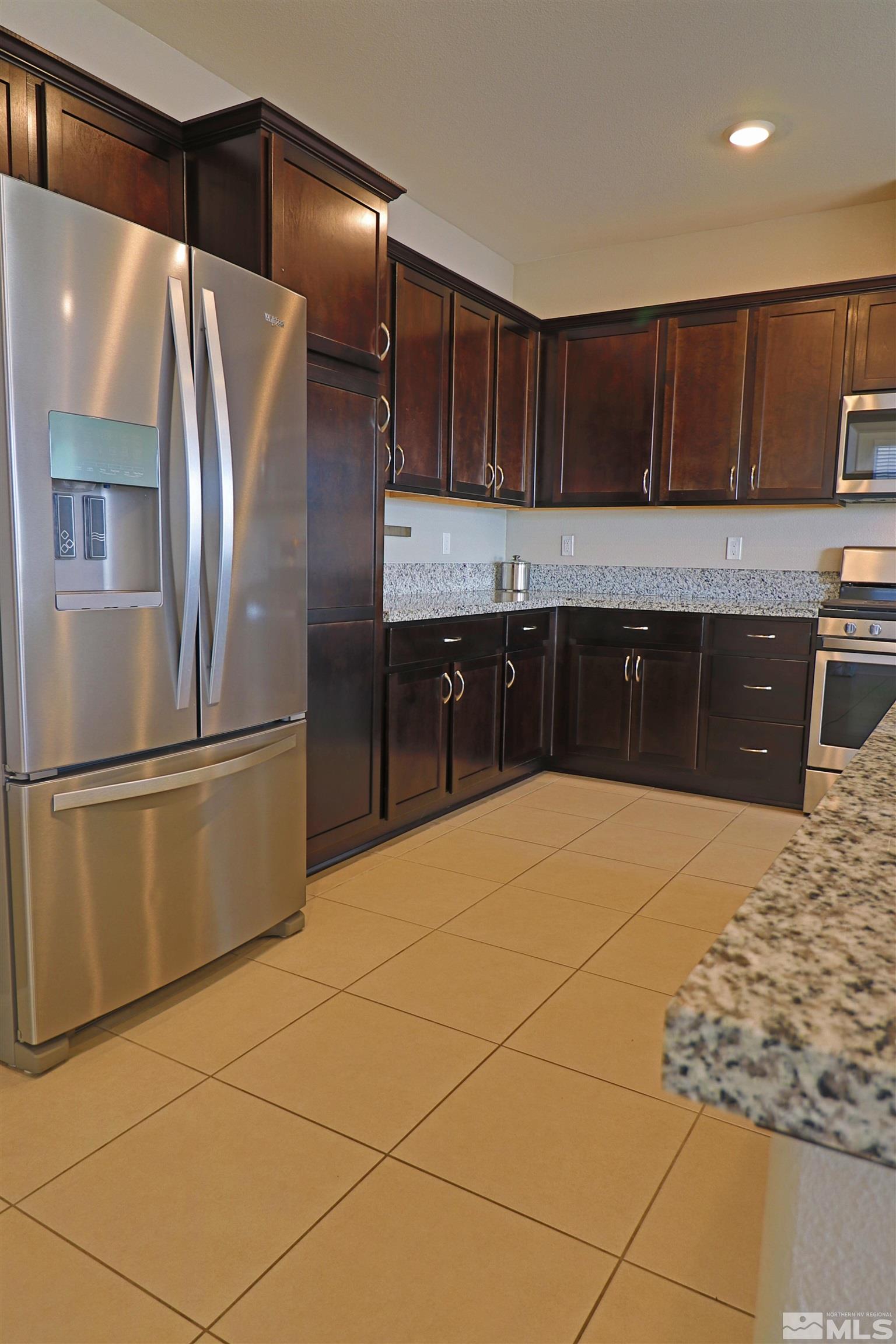 1920 Dark Horse Road, Unit C Reno, NV 89521 - Photo 8 of 26 a kitchen with granite countertop a refrigerator and a stove top oven