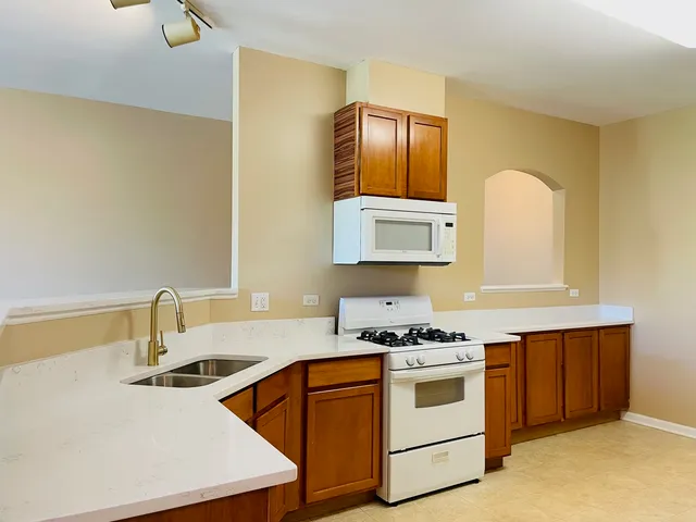 a kitchen with granite countertop a sink stove and cabinets