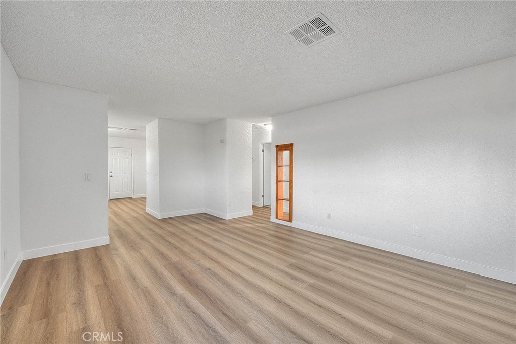22133 Thunderbird Road Apple Valley, CA 92307 - Photo 11 of 29 a view of an empty room and wooden floor