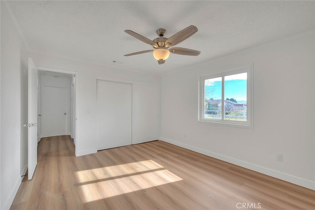 22133 Thunderbird Road Apple Valley, CA 92307 - Photo 14 of 29 a view of a room with wooden floor and a ceiling fan