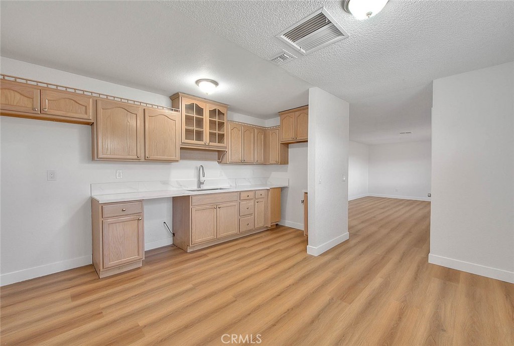 22133 Thunderbird Road Apple Valley, CA 92307 - Photo 4 of 29 a kitchen with stainless steel appliances granite countertop a sink cabinets and wooden floor