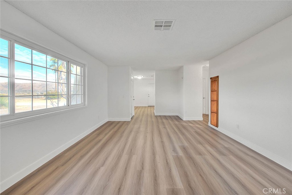 22133 Thunderbird Road Apple Valley, CA 92307 - Photo 10 of 29 a view of empty room with wooden floor and fan